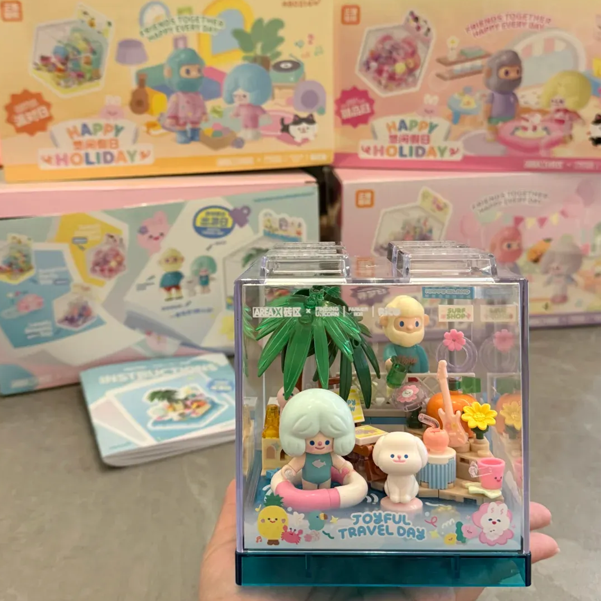 Rico & Bob - Travel Day playset inside a clear display cube, featuring beach-themed characters and decorations.