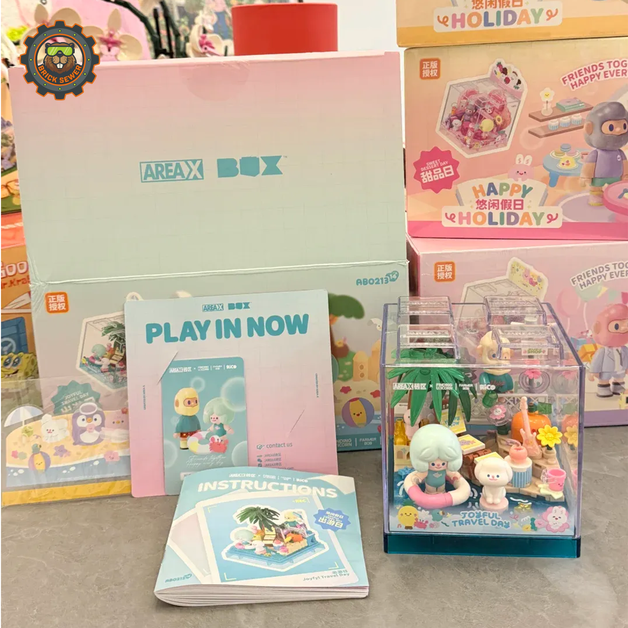 Rico & Bob - Travel Day display featuring vacation scene with tropical theme and playful characters in a clear cube.